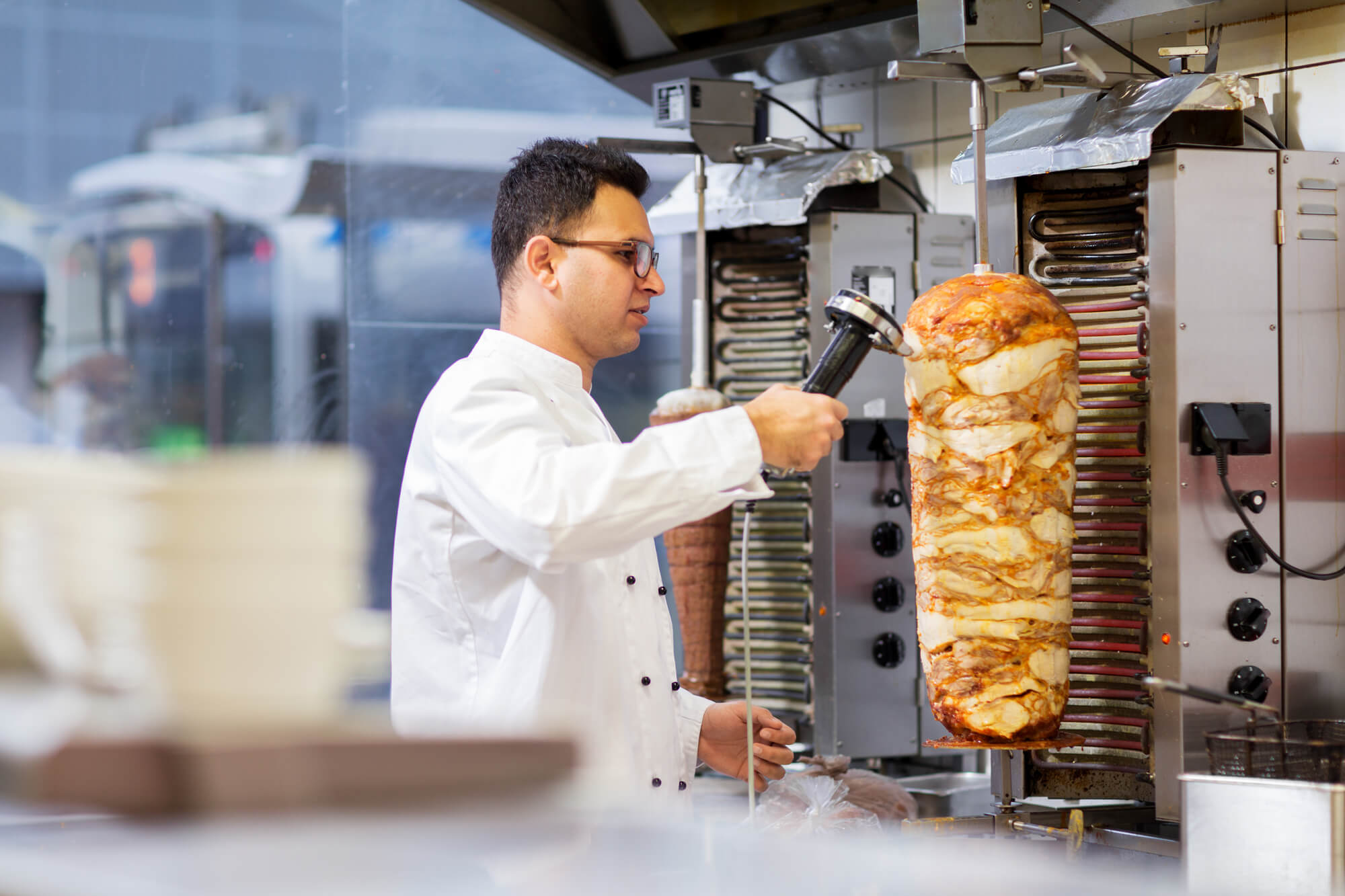 Chef slicing a doner insider a kebab house. 